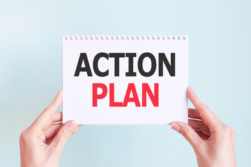 ACTION PLAN word inscription on white card paper sheet in hands of a woman. Business concept