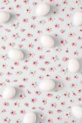 2021 Easter creative layout made with spring flower and white Easter eggs on light grey background. Minimal  holiday still life composition.