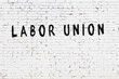 White wall with black paint inscription labor union on it