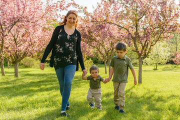 Mother and children walking in a park in Spring