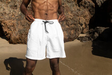 African American man in white swim shorts at the beach