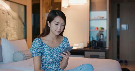 Canvas Print - Woman use of mobile phone on bed at night