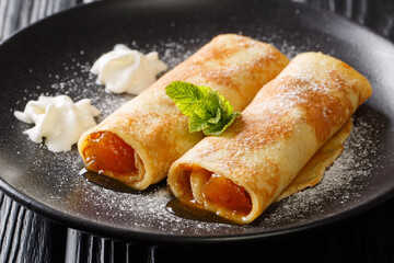 Wall Mural - Palatschinken Austrian Sweet Pancakes with apricot jam close-up in a plate on the table. horizontal