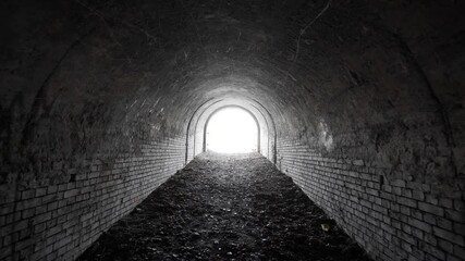 exit from the old abandoned brick arch tunnel of the 19th century fortification with light in the en