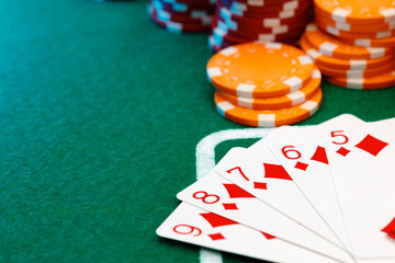 Playing cards and chips on green casino table background