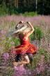 © Nataliia Makarovska - cute little blonde girl in an elegant fairy dress whirl in the flowers of fireweed forest. Evening sun rays. Festive mood, birthday during the global pandemic, Coronovirus.
