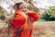 © iuricazac - Candid outdoor portrait of a gorgeous young woman with long blonde hair smiling in the park. Female wearing an orange sweater has joyful expression on the nature background.