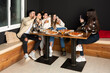 © Jordi Mora - groups of young people take a selfie photo while eating pizzas at a restaurant
