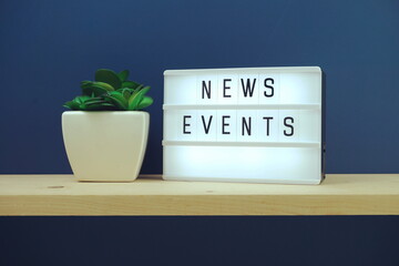 Wall Mural - News Events word in light box on blue and wooden shelves background