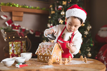 young girl making gingerbread house at home