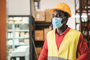 Sticker - African man working inside warehouse while wearing safety mask during coronavirus outbreak - Focus on face