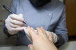 © Roman - client is undergoing a procedure with a manicure master. Manicurist apply gel polish to nails