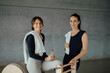 © BASILICOSTUDIO STOCK - Smiling caucasian fit women in sport clothing looking at camera in a gym, fitness center. Female aerobics instructors with towels and water bottle, taking a break between classes in a health club.