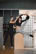 © BASILICOSTUDIO STOCK - Portrait of females personal trainer and client in a big pilates studio wearing sportswear and protective face masks, looking at camera smiling, Yoga posture. Fitness, well being in a health club.