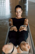© BASILICOSTUDIO STOCK - Hands of a beautiful smiling fit woman in sport clothing working out at Fitness center studio. Front view of flexible female pulling strings of a pilates reformer machine in gym, rowing. Close up