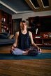 © chika_milan - A middle-aged woman sitting in a lotus yoga pose and meditating with eyes closed.