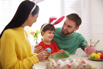 Poster - Happy family painting Easter eggs at table indoors