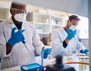 Two male lab technicians analyzing samples at a table