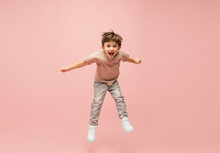 Flying High. Happy, Smiley Little Caucasian Boy Isolated On Pink Studio Background With Copyspace For Ad. Looks Happy, Cheerful. Childhood, Education, Human Emotions, Facial Expression Concept.