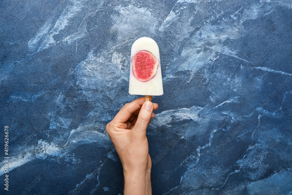 Woman with delicious fig ice-cream on color background
