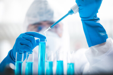 Researchers scientist working analysis with blue liquid test tube in the laboratory, chemistry science or medical biology experiment technology, pharmacy development solution