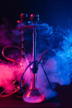 Fashionable Hookah With A Cloud Of Smoke On A Black Background With Red And Blue Glow