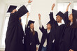 © Studio Romantic - Boys and girls are happy to be graduates. Group of happy multiracial students in mortarboard and bachelor gown joyfully raise their hands up to celebrate graduation. Success concept.
