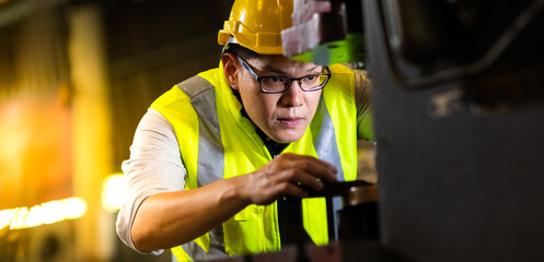 Wall Mural - Asian man worker wearing safety hardhat helmet control lathe machine to drill components. Metal lathe industrial manufacturing factory