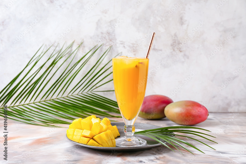 Glass of tasty mango margarita on light background