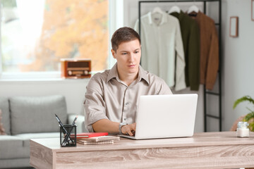 Handsome young man using laptop at home