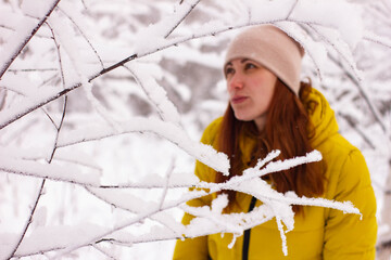 portrait of a sexy attractive young woman in winter among the trees in the other and snow