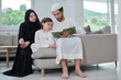 © .shock - Young muslim family reading Quran during Ramadan