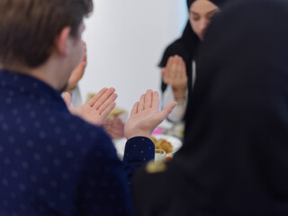 Wall Mural - Muslim family making iftar dua to break fasting during Ramadan