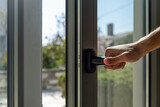 Fototapeta Panele - Aluminum window frame detail. Male hand opens the metal door closeup view.