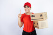 © Irene - Young beautiful woman wearing courier uniform holding delivery packages showing and pointing up with fingers number one while smiling confident and happy