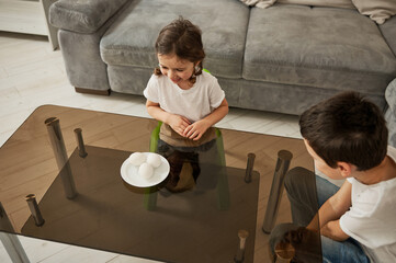 High anle view of two children decorating Easter eggs