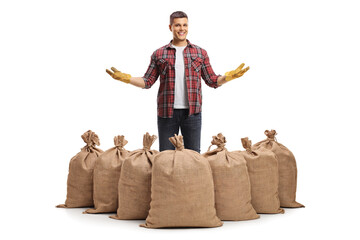 Wall Mural - Full length portrait of a farmer showing burlap sacks