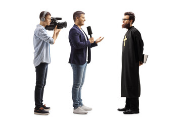 Wall Mural - Reporter interviewing a catholic priest and a cameraman recording