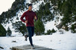 © Aitor Carrera Port√©/Westend61 - Determined young male athlete running on footbridge while listening music during winter