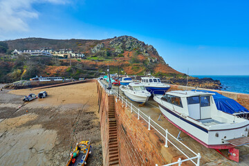 Wall Mural - Image of Bonne Nuit Harbour at low tide in the winter with blue sky. Jersey, Channel Islands