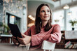 © Joseffson/Westend61 - Female professional with digital tablet looking away while sitting cafe