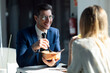 © JOSEP SURIA/Westend61 - Business people having lunch while sitting in cafeteria at office