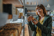 © Mareen Fischinger/Westend61 - Smiling mature woman looking at label on bottle while shopping in retail shop
