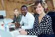 © JOSEP SURIA/Westend61 - Smiling businessman and businesswomen sitting at desk in coworking office