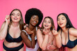 © OneInchPunch/Westend61 - Cheerful multi-ethnic female models in lingerie holding beauty products against pink background