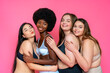© OneInchPunch/Westend61 - Smiling group of multi-ethnic female models in lingerie embracing each other against pink background