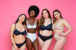 © OneInchPunch/Westend61 - Multi-ethnic group of female models in lingerie standing with arms around waist against pink background