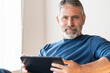 © steve brookland/Westend61 - Confident businessman using digital tablet while sitting at home