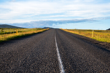 Wall Mural - Empty road lit by midnight sun in the countryside of Iceland in summer