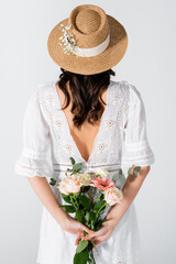 Sticker - back view of woman in straw hat and dress holding bouquet isolated on white